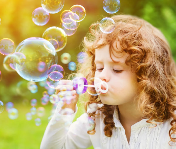 happy girl blowing bubbles